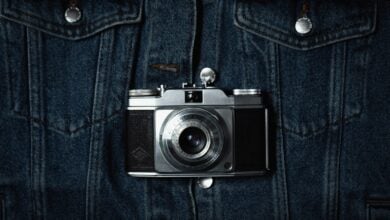 a camera hanging on the back of a jean jacket